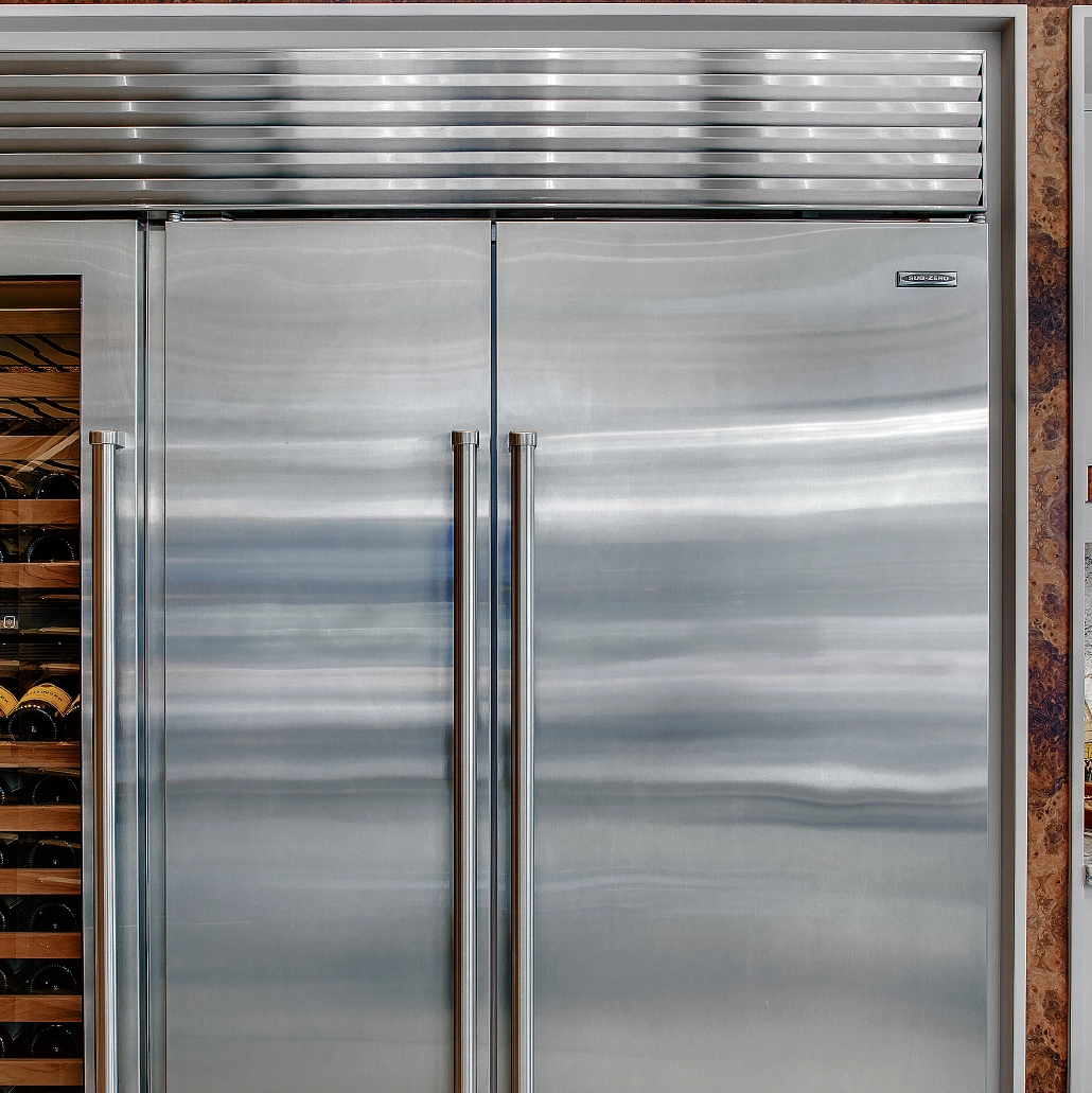 Professional Sub-Zero refrigerator repair technician working on luxury appliance in Cherry Creek home